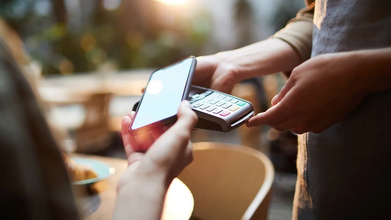 Persona pagando su cuenta en terminal de pago